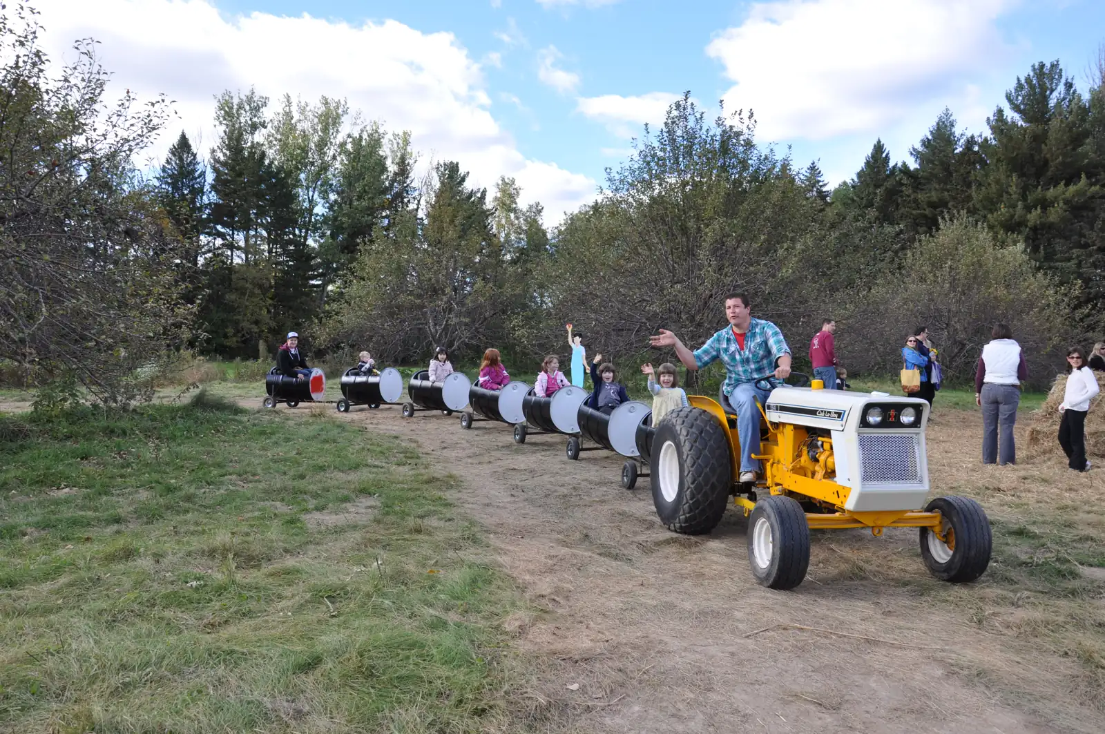 Kids waving from the Honeycrisp Express barrel train