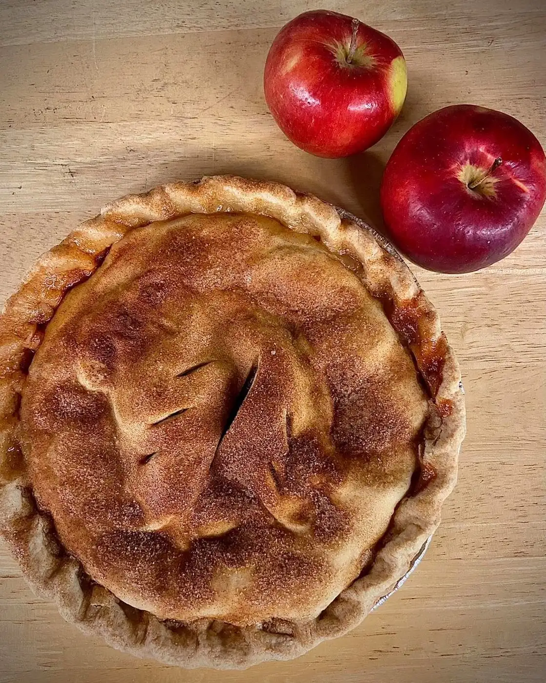 A cinnamon-sugar apple pie fresh from the Aamodt's bakery, with two of our apples